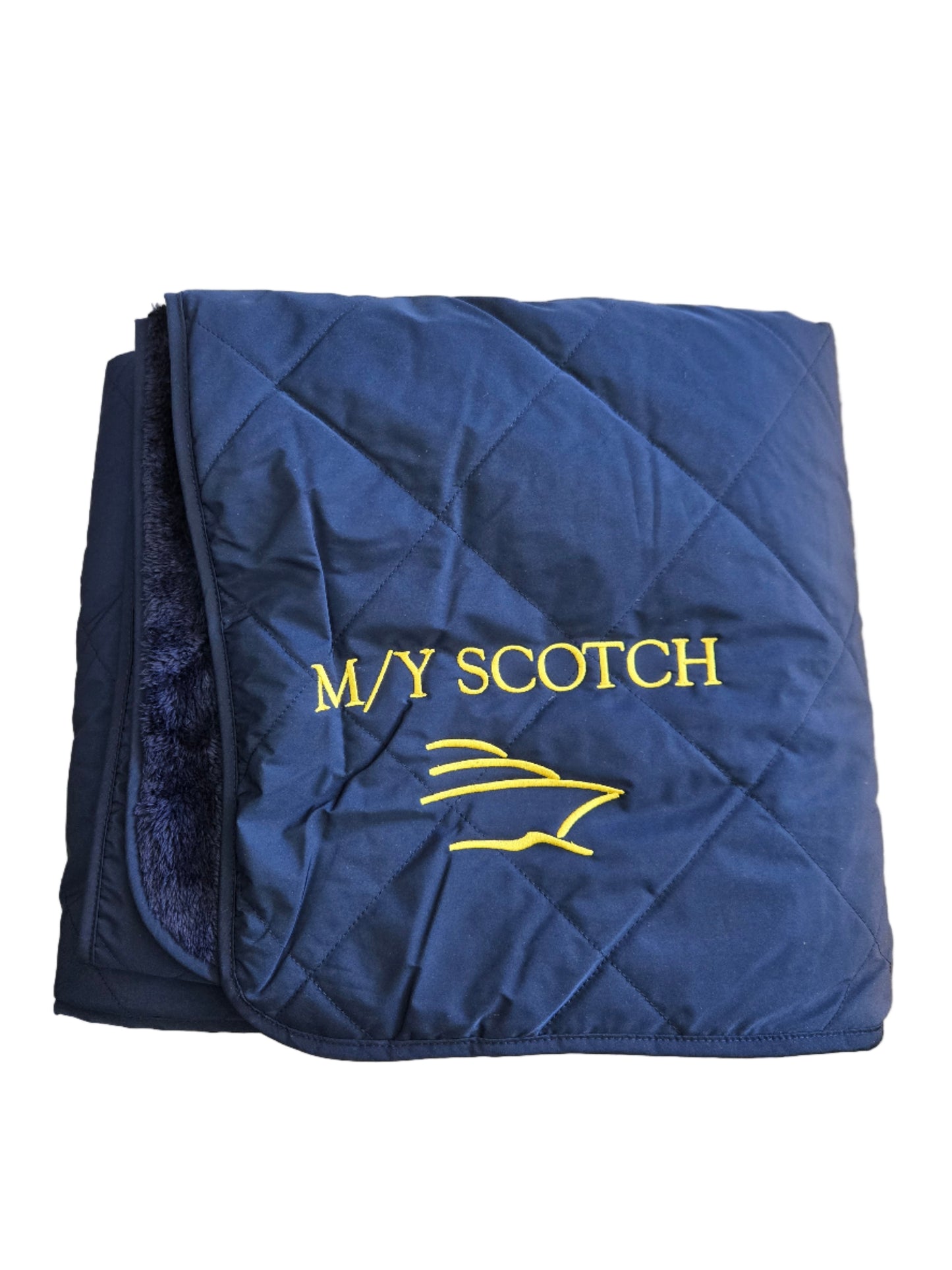 Folded blue blanket with 'MY SCOTCH' embroidered with a boat logo