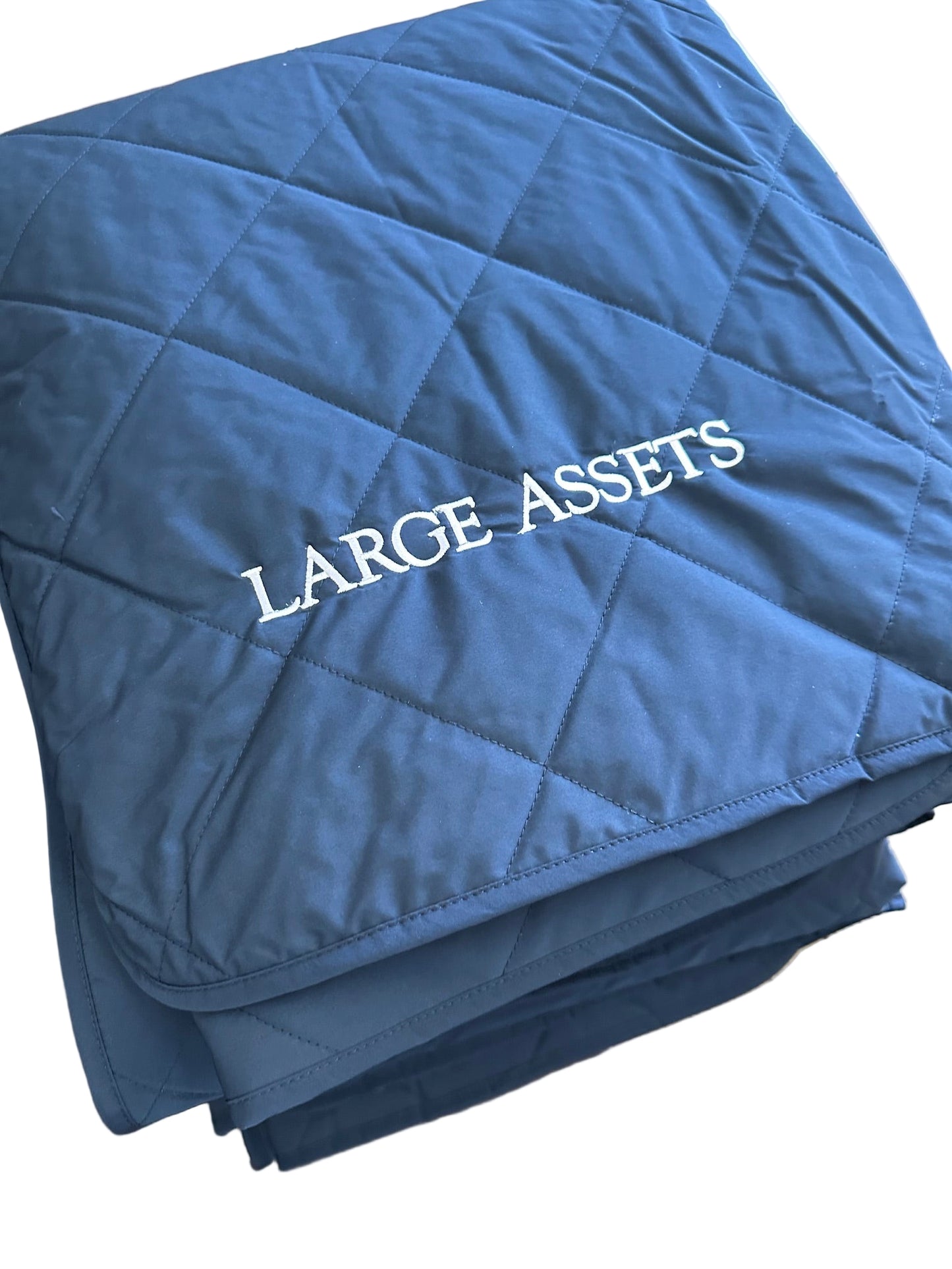 Blue quilted blanket with 'LARGE ASSETS' text 